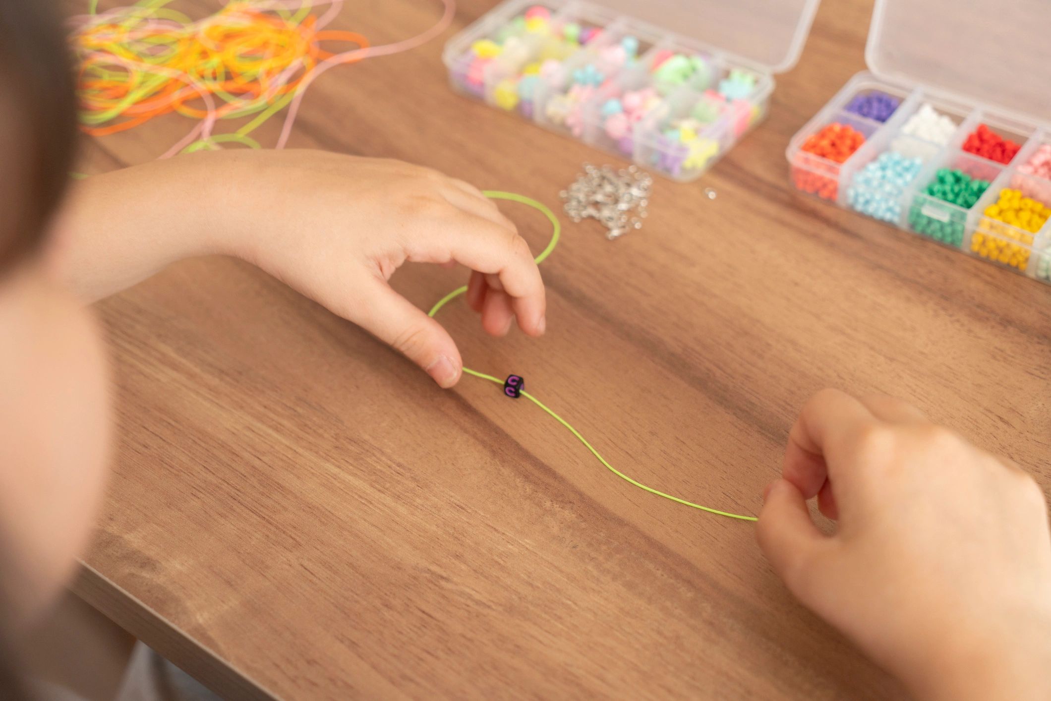 children making beaded bracelets jewelry playful