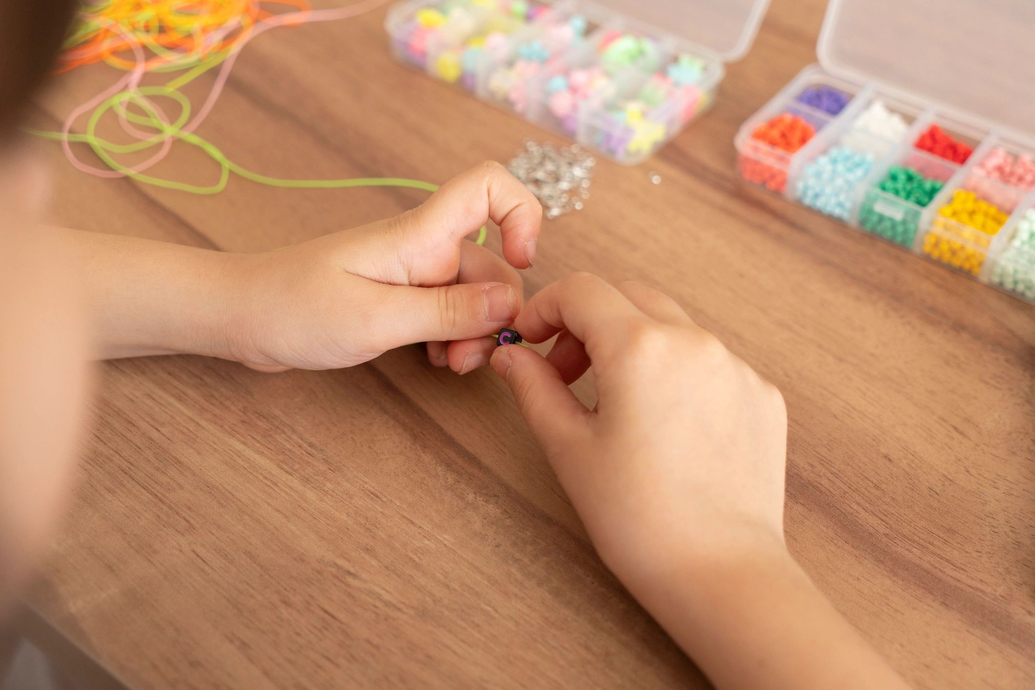 child hands with beaded bracelets creative